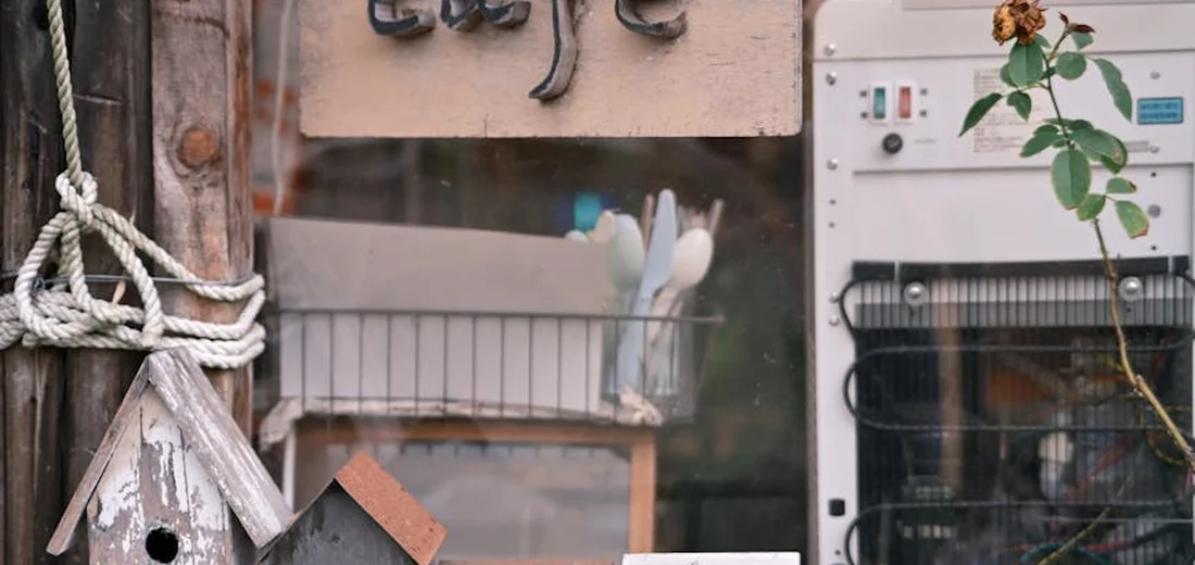 A garden shop display with rope and tools, a wooden sign, and a small trailing plant by a window, illustrating filler and trailing succulent ideas.