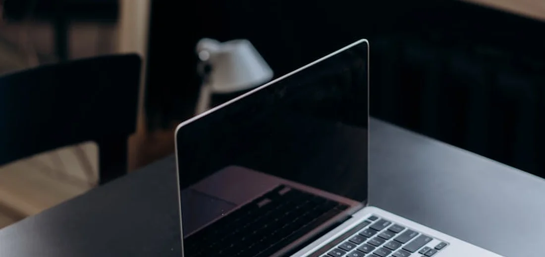 Open laptop on a dark desk with a softly blurred background, symbolizing careful planning for plant recovery.
