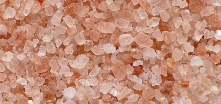 Close-up of pink granular fertilizer pellets.