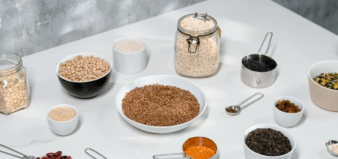 Assorted seeds displayed in glass jars and small bowls on a bright table, illustrating an in-store seed display for succulents.